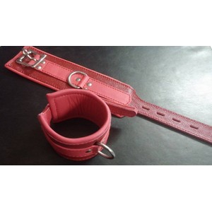 A pair of high-quality, wide red leather handcuffs with a metal loop​